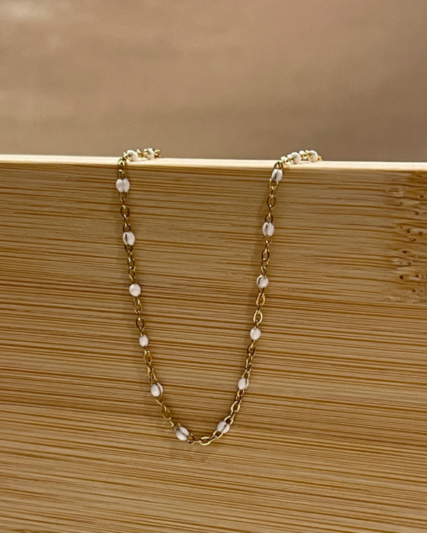 Image d'un bracelet à perles blanc et doré de la boutique Erika.